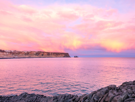 Coastline view with mountains near Dyrholaey, Vik town in Iceland, during twilight evening sky in...