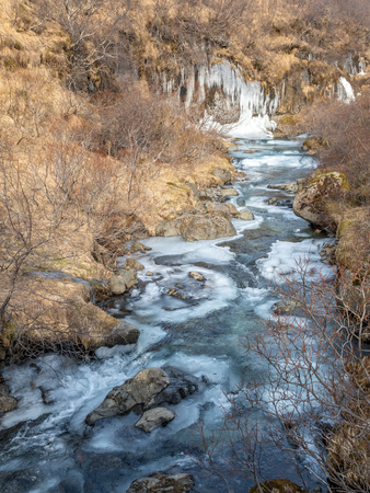 Frozen river in Skaftafell national park, near Svartifoss waterfall in winter season of Icelandの写真素材