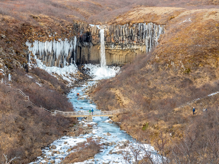 Svartifoss waterfall, one of unique landmark in Iceland, located in Vatnajokull national park, like oasis in black larva sand plain, water freeze in winter seasonの写真素材