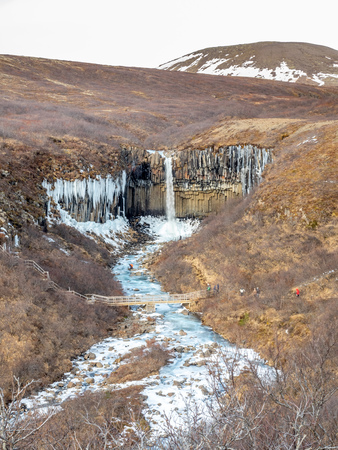Svartifoss waterfall, one of unique landmark in Iceland, located in Vatnajokull national park, like oasis in black larva sand plain, water freeze in winter seasonの写真素材