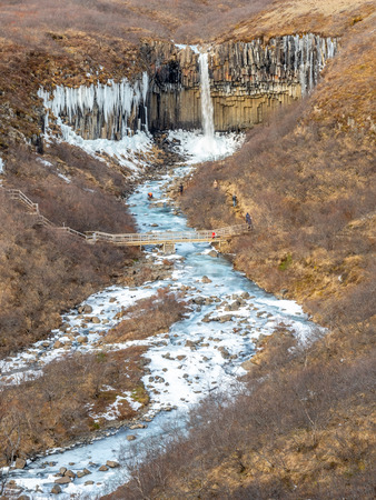 Svartifoss waterfall, one of unique landmark in Iceland, located in Vatnajokull national park, like oasis in black larva sand plain, water freeze in winter seasonの写真素材