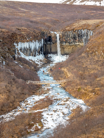Svartifoss waterfall, one of unique landmark in Iceland, located in Vatnajokull national park, like oasis in black larva sand plain, water freeze in winter seasonの写真素材