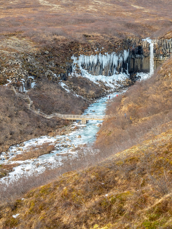 Svartifoss waterfall, one of unique landmark in Iceland, located in Vatnajokull national park, like oasis in black larva sand plain, water freeze in winter seasonの写真素材