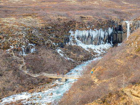 Svartifoss waterfall, one of unique landmark in Iceland, located in Vatnajokull national park, like oasis in black larva sand plain, water freeze in winter seasonの写真素材