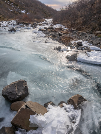 Frozen river in Skaftafell national park, near Svartifoss waterfall in winter season of Icelandの写真素材
