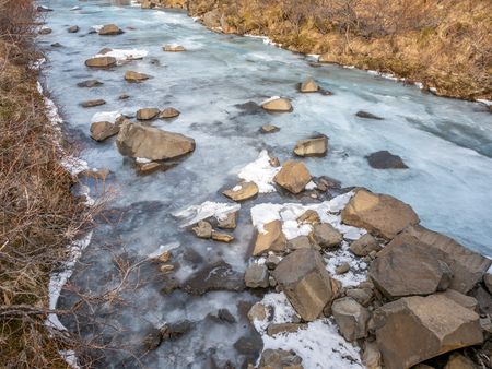Frozen river in Skaftafell national park, near Svartifoss waterfall in winter season of Icelandの写真素材