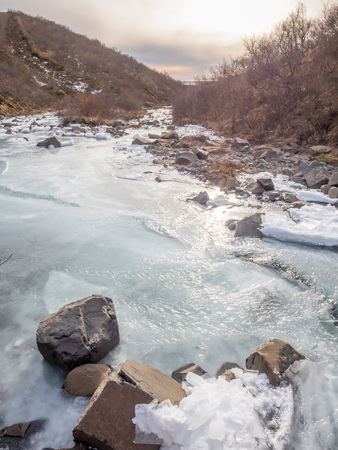 Frozen river in Skaftafell national park, near Svartifoss waterfall in winter season of Icelandの写真素材