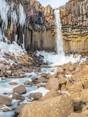 Svartifoss waterfall, one of unique landmark in Iceland, located in Vatnajokull national park, like oasis in black larva sand plain, water freeze in winter seasonの写真素材