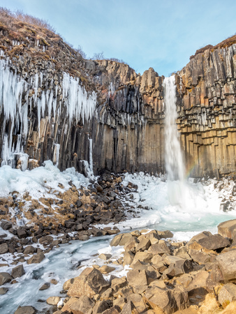 Svartifoss waterfall, one of unique landmark in Iceland, located in Vatnajokull national park, like oasis in black larva sand plain, water freeze in winter seasonの写真素材