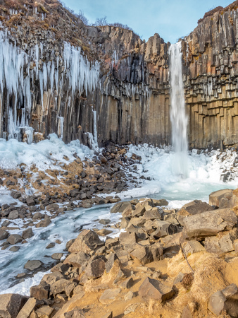 Svartifoss waterfall, one of unique landmark in Iceland, located in Vatnajokull national park, like oasis in black larva sand plain, water freeze in winter seasonの写真素材