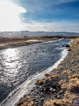 Frozen water in river under Gluggafoss waterfall in winter season, Icelandの写真素材
