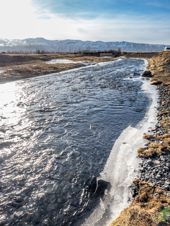Frozen water in river under Gluggafoss waterfall in winter season, Icelandの写真素材