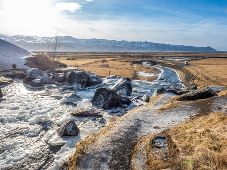 Frozen water in river under Gluggafoss waterfall in winter season, Icelandの写真素材