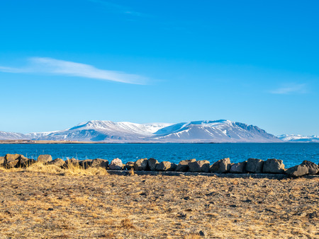 Mountains, field and seascape view in Akranes town near peninsula and lighthouses in wtiner season, Icelandの写真素材