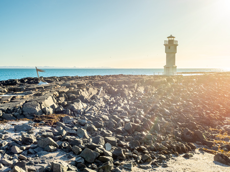 The old inactive Arkranes lighthouse at end of peninsula, was built since 1918, under blue sky, Icelandの写真素材