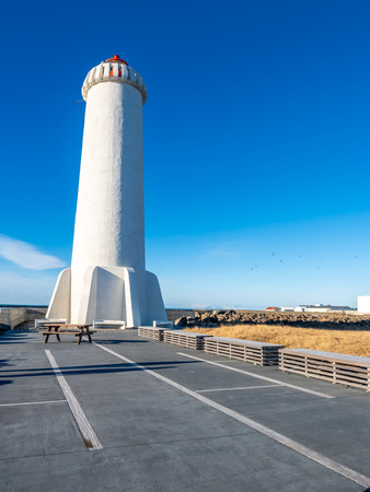 The new active Akranes lighthouse tower at end peninsula in city under blue sky, Icelandの写真素材
