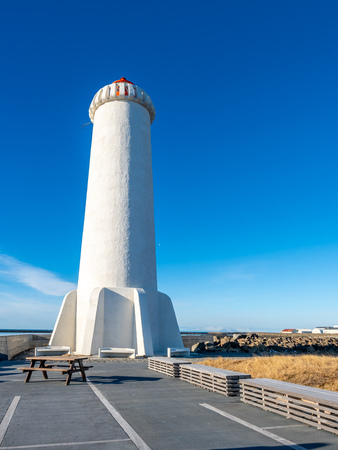 The new active Akranes lighthouse tower at end peninsula in city under blue sky, Icelandの写真素材