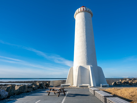The new active Akranes lighthouse tower at end peninsula in city under blue sky, Icelandの写真素材
