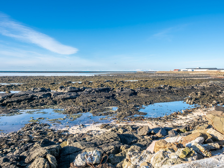 Large stones at Akranes peninsula near the lighthouses under blue sky, Icelandの写真素材