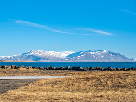 Mountains, field and seascape view in Akranes town near peninsula and lighthouses in wtiner season, Icelandの写真素材