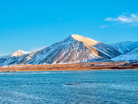 Mountains, sea and coastline view in winter season under blue sky in Icelandの写真素材