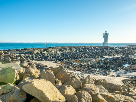 The old inactive Arkranes lighthouse at end of peninsula, was built since 1918, under blue sky, Icelandの写真素材
