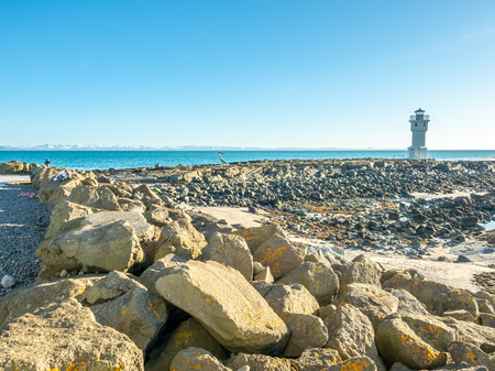 The old inactive Arkranes lighthouse at end of peninsula, was built since 1918, under blue sky, Icelandの写真素材