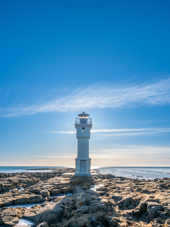 The old inactive Arkranes lighthouse at end of peninsula, was built since 1918, under blue sky, Icelandの写真素材