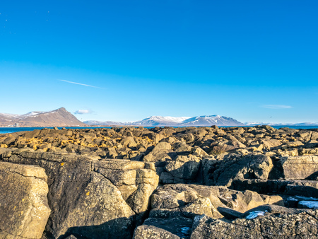 Large stones at Akranes peninsula near the lighthouses under blue sky, Icelandの写真素材