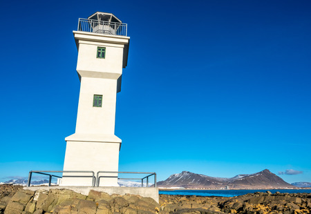The old inactive Arkranes lighthouse at end of peninsula, was built since 1918, under blue sky, Icelandの写真素材