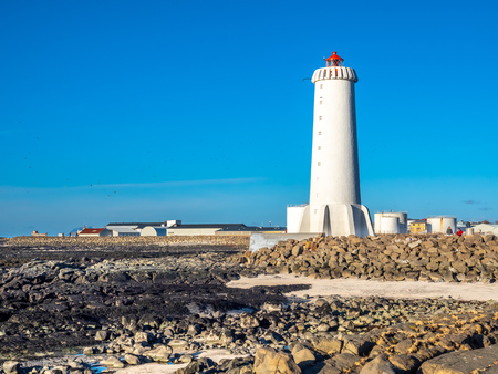 The new active Akranes lighthouse tower at end peninsula in city under blue sky, Icelandの写真素材