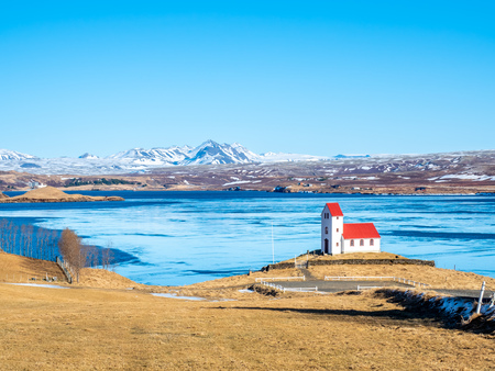Church on lake Ulfljotsvatn, known as Ulfljotsvatnskirkja, is landmark of southern of Iceland, beautiful viewpoint under clear blue sky in winter seasonの写真素材