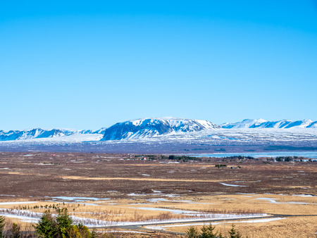 Landscape beautiful view, lake, mountains and field under cloudy blue sky in winter season, Icelandの写真素材