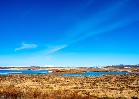 Landscape beautiful view, lake, mountains and field under cloudy blue sky in winter season, Icelandの写真素材