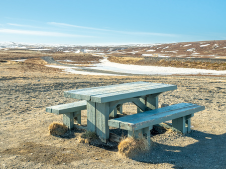 Wooden bench and table at outdoor place with beautiful landscape view in Icelandの写真素材