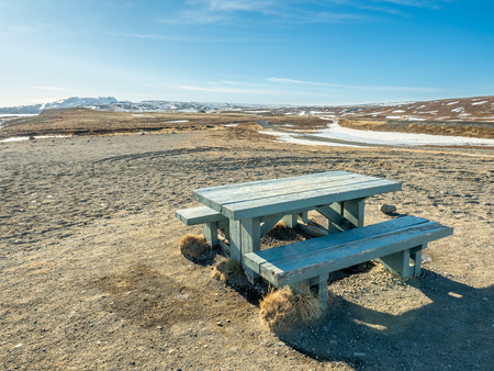Wooden bench and table at outdoor place with beautiful landscape view in Icelandの写真素材