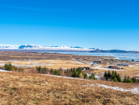 Landscape beautiful view, lake, mountains and field under cloudy blue sky in winter season, Icelandの写真素材