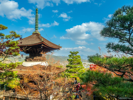 Arashiyama cityscape viewpoint with autumn tree forest under cloudy blue sky with mountains in background and landmark Japanese style pagoda, Japanのeditorial素材