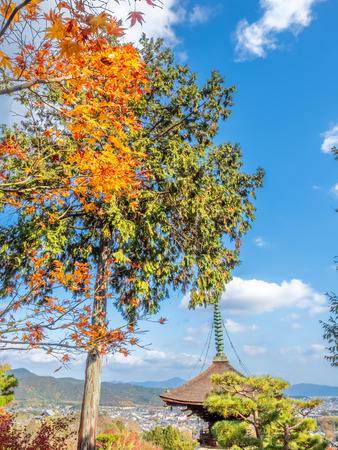 Arashiyama cityscape viewpoint with autumn tree forest under cloudy blue sky with mountains in background and landmark Japanese style pagoda, Japanのeditorial素材