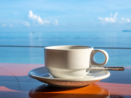 Coffee cup with white dish and spoon with seascape view at Samui island, Thailandの写真素材