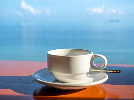 Coffee cup with white dish and spoon with seascape view at Samui island, Thailandの写真素材