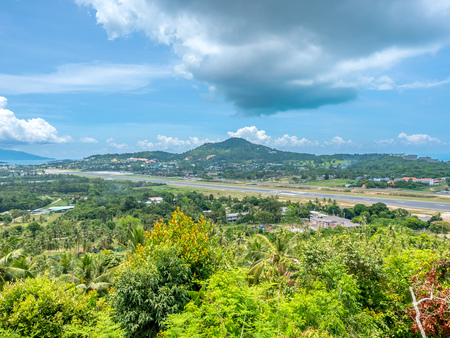 Viewpoint to runway at Samui airport with cityscape view of Samui island, Suratthani, Thailand, in summer season, under cloudy blue skyの写真素材