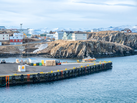STYKKISHOLMUR, ICELAND - MARCH 9 : Commercial harbor with ships and boats in bays with cityscape...