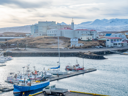 STYKKISHOLMUR, ICELAND - MARCH 9 : Commercial harbor with ships and boats in bays with cityscape...