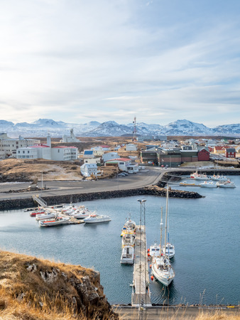 STYKKISHOLMUR, ICELAND - MARCH 9 : Commercial harbor with ships and boats in bays with cityscape view at Stykkisholmur town in Iceland, was taken on March 9, 2018.のeditorial素材