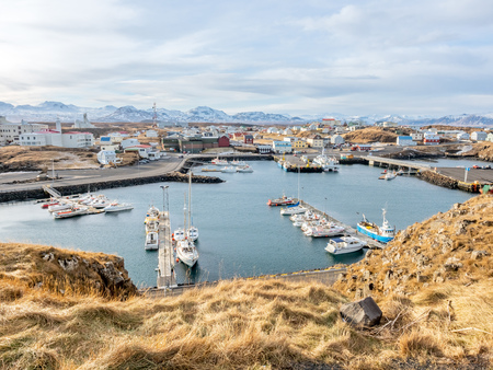 STYKKISHOLMUR, ICELAND - MARCH 9 : Commercial harbor with ships and boats in bays with cityscape view at Stykkisholmur town in Iceland, was taken on March 9, 2018.のeditorial素材