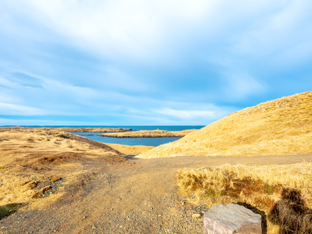Seascape view with moutain under cloudy blue sky from Stykissholmur lighthouse hill in winter season, Icelandの写真素材