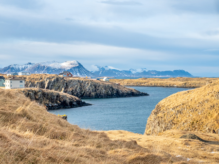 Seascape view with moutain under cloudy blue sky from Stykissholmur lighthouse hill in winter season, Icelandの写真素材