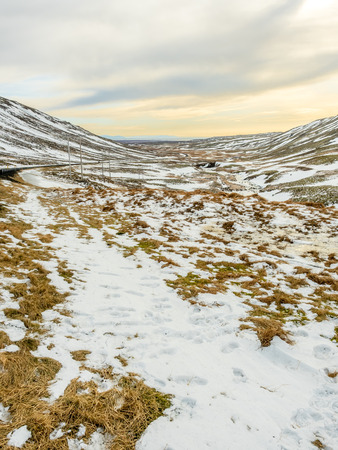 Landscape view with snow in winter season under cloudy sky along road side in Icelandの写真素材