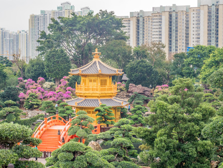 HONG KONG, CHINA - JANUARY 20 : Outdoor garden with tree, pavilion and buildings with pond with skyscraper buildings in background, Hong Kong, China, on January 20, 2018.のeditorial素材